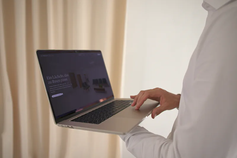 Laptop mit der Website der Konzeptstudie Lumera Dental vor einem hellen Vorhang